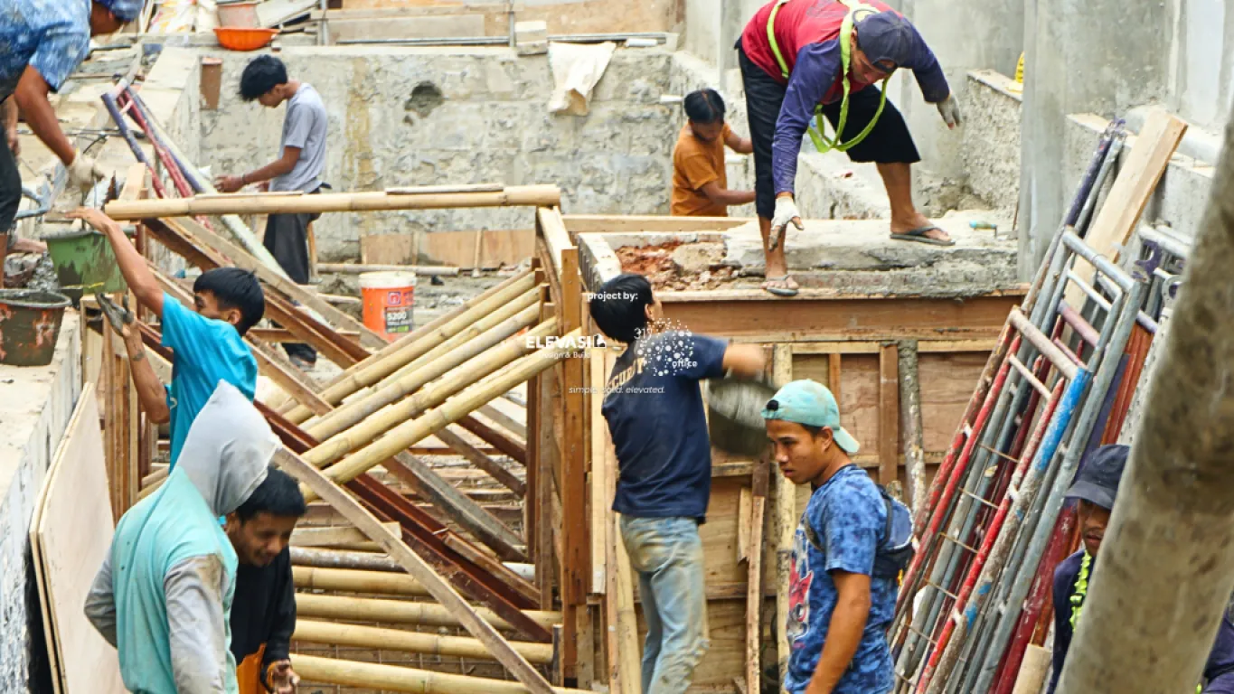 Construction workers performing concrete pouring.